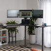 triple monitor arm setup on the vari l shape desk in the corner of a workspace