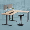 Remote pro bundle setup includes an electric standing desk a table and dual monitor arms with an active seat and power hub