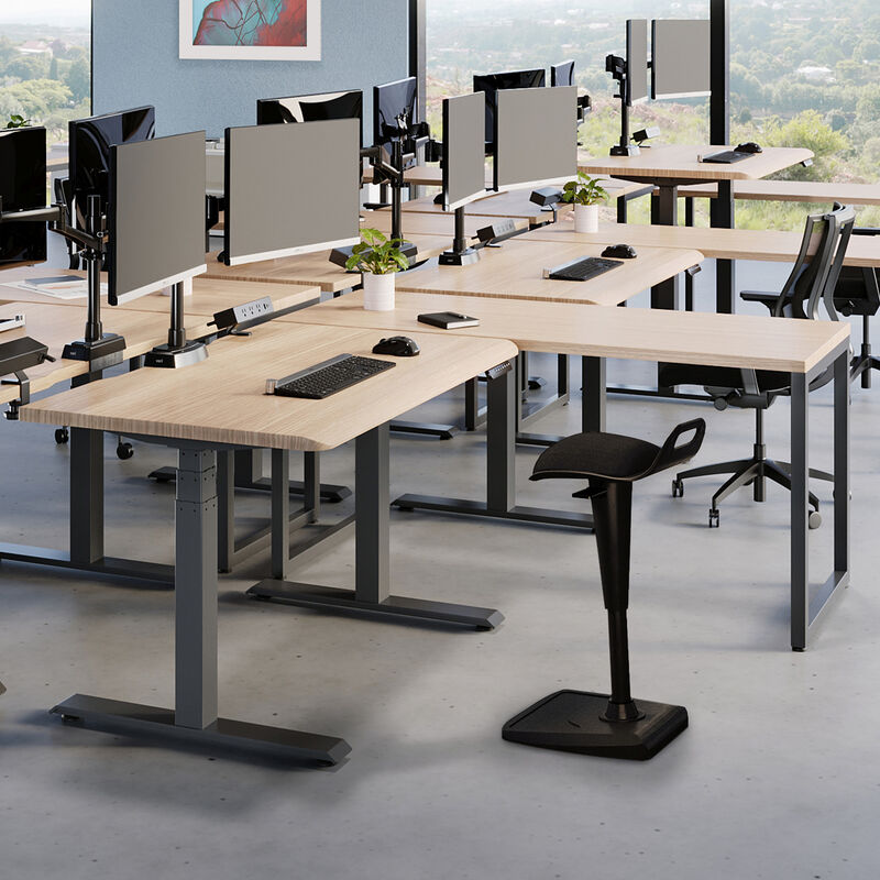 Remote pro bundle setup in an open workspace with a electric standing desk a table and dual monitor arms with an active seat and power hub image number null