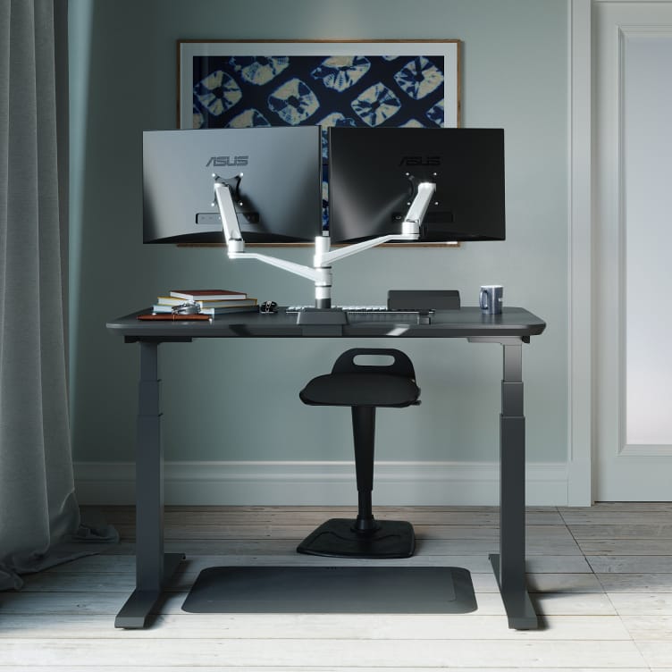 at home workspace with an electric standing desk and chair