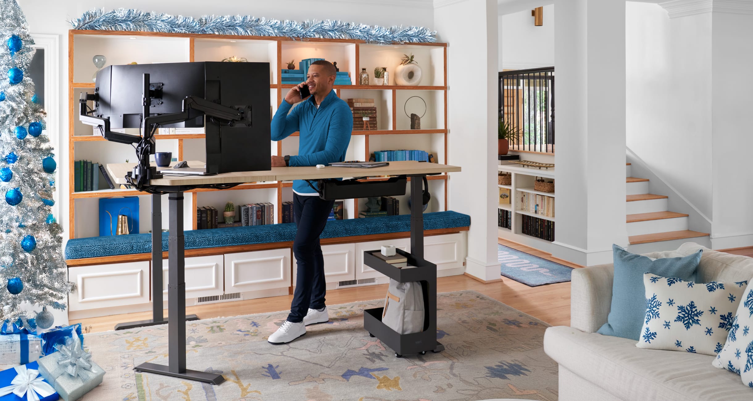 individual standing on the phone behind a standing desk in a living room home office 